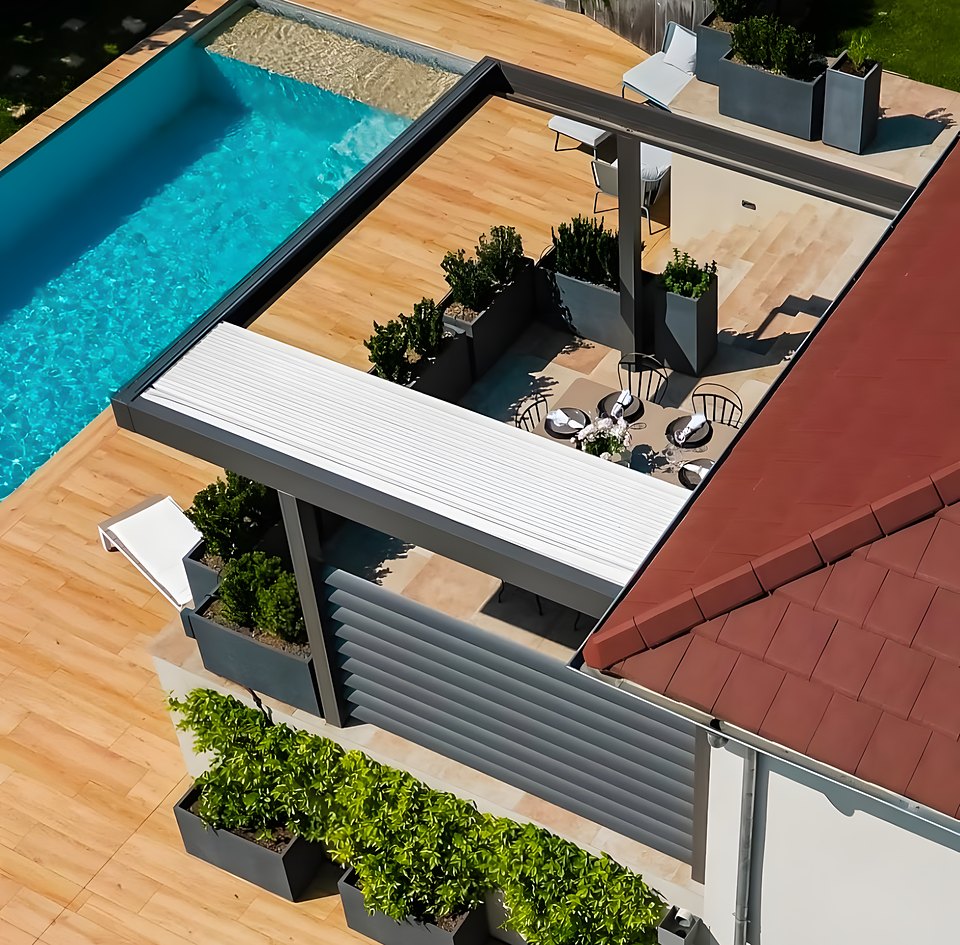 Vista dall'alto di una pergola bioclimatica con lamelle chiuse accanto alla piscina di una villa